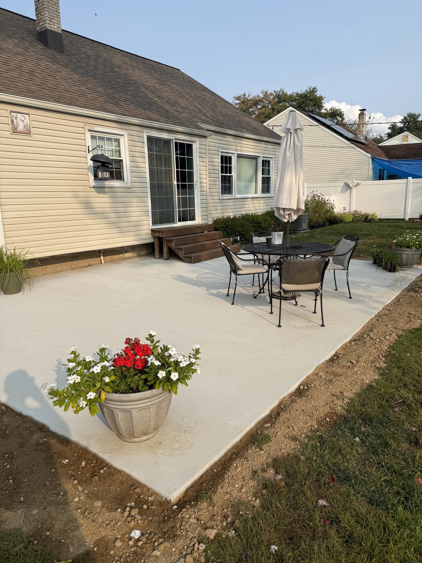Backyard concrete patio set up with outdoor furniture and umbrella in Newark, DE