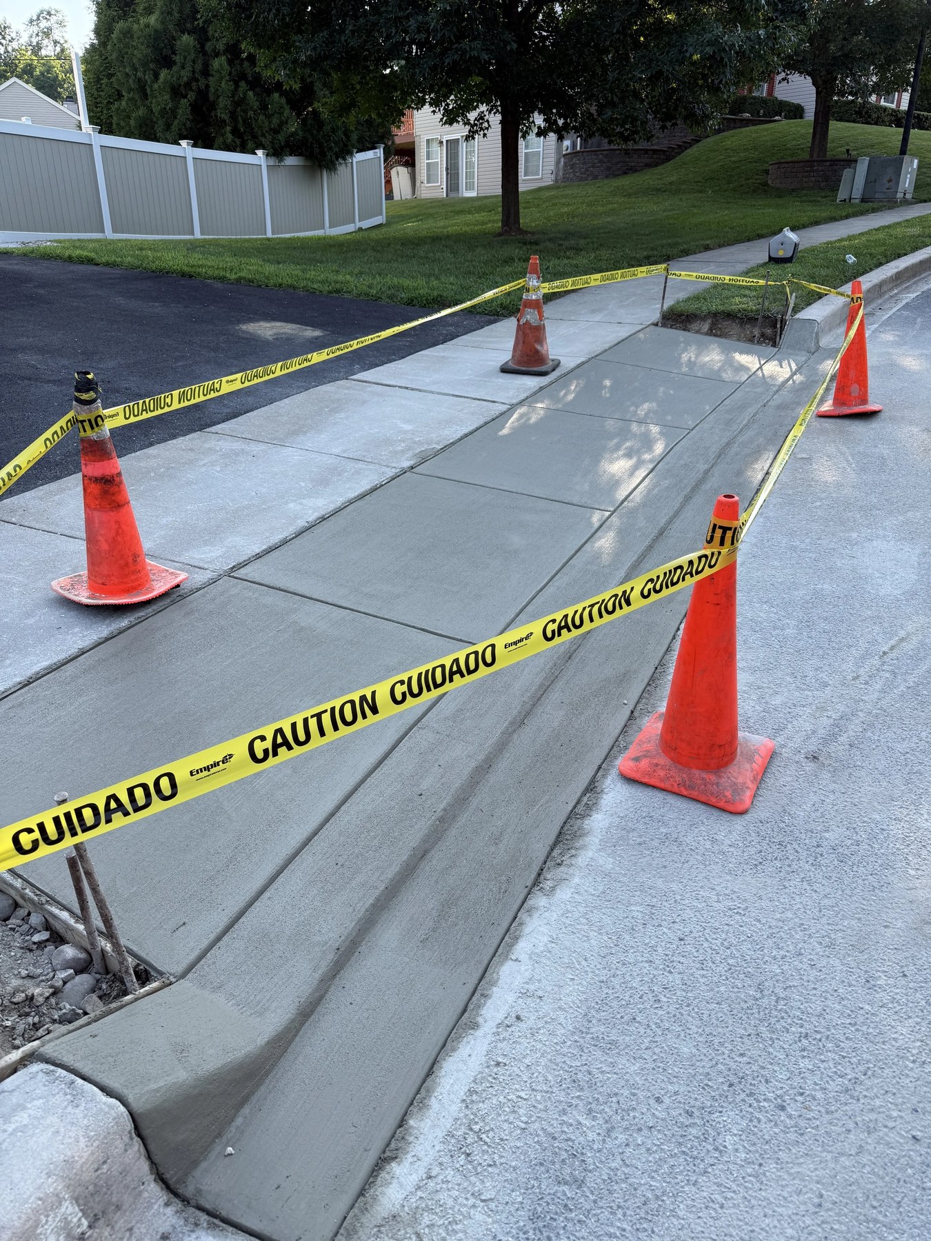 Concrete sidewalk section curing with cones and caution tape in New Castle County, DE