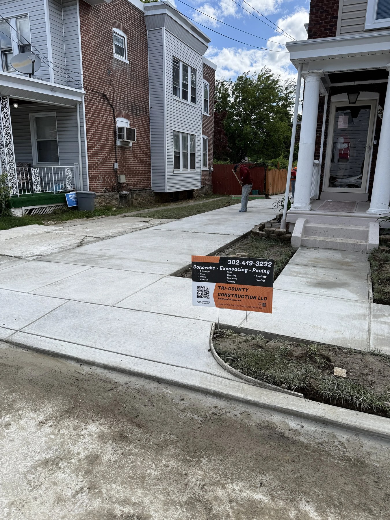 New concrete sidewalk with Tri-County Construction job sign in New Castle, DE